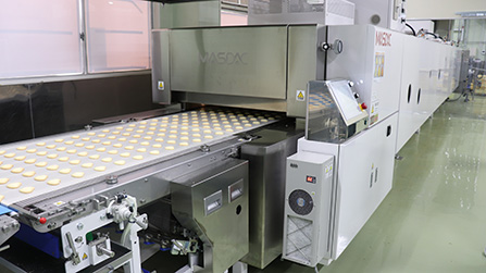 The Tunnel Oven dedicated to “Komeko no Cookies Hiyone.” The baked cookies are cooled in a Clean Cooling Tunnel before they are packaged.